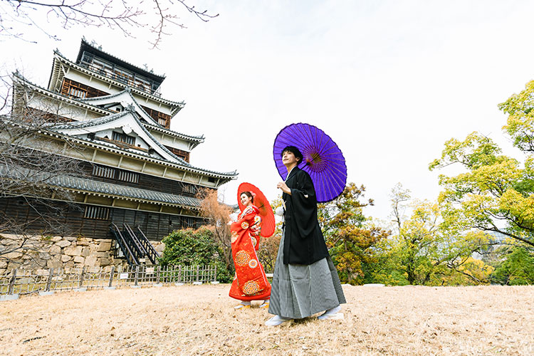 広島城の天守閣を背景に和装で撮影するカップルのフォトウェディング前撮り