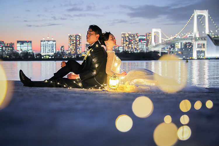 お台場海浜公園でレインボーブリッジを背景にした夜の前撮り