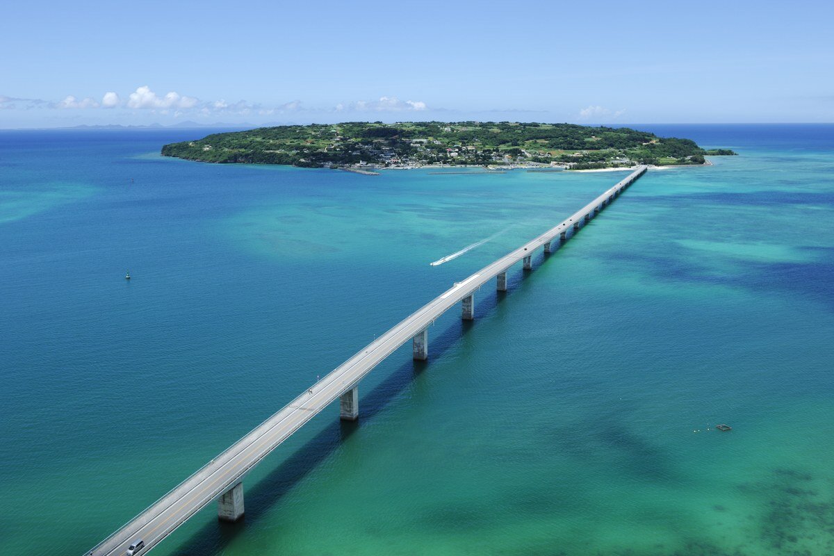 沖縄の海辺で笑い合う両家の家族